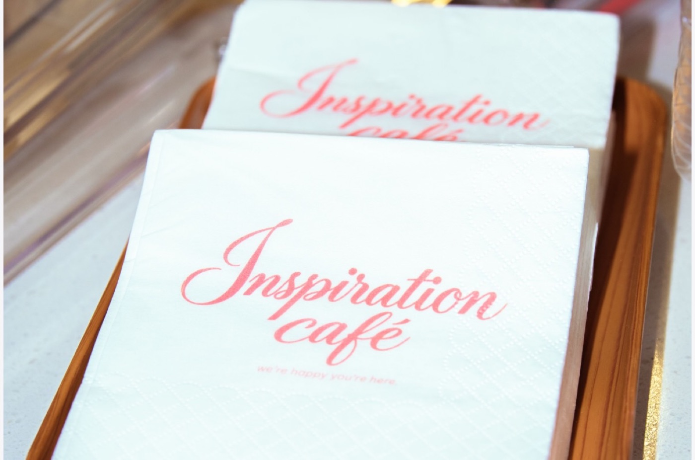 Inspiration Café napkins printed with the café's coral script logo