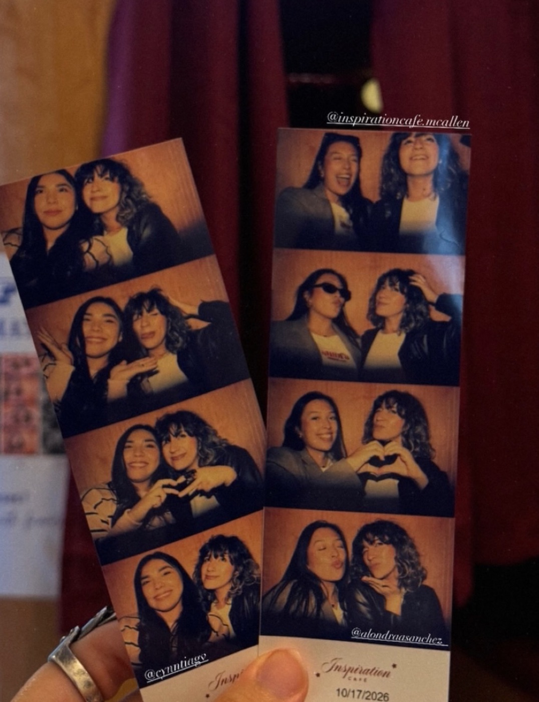 Two colour photobooth strips held up in front of the booth's curtain