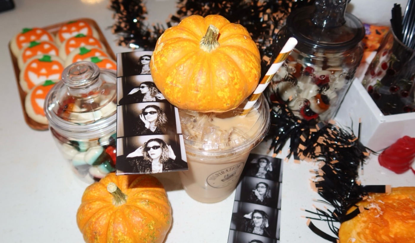 A pumpkin spice latte with small pumpkins